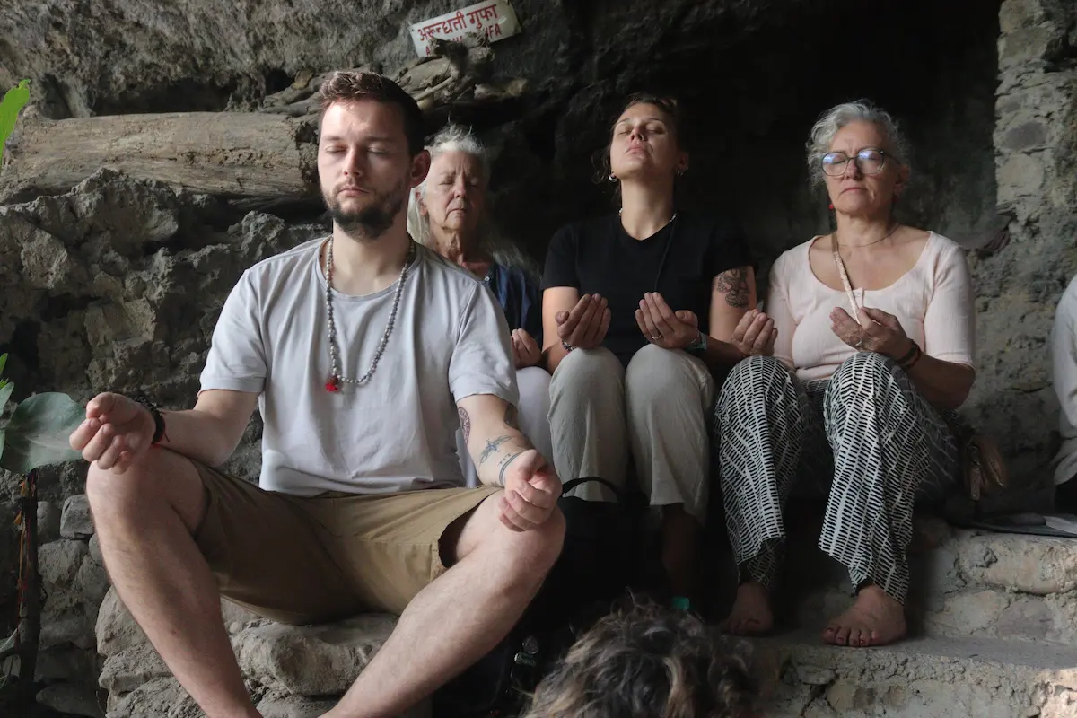 Retreat participants seated together in meditation inside a cave