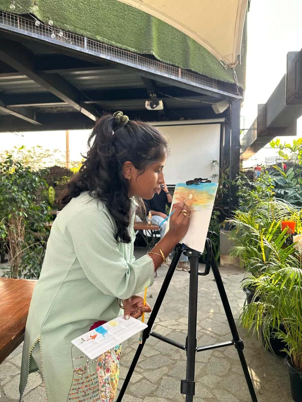 Participant painting a wall mural during an expressive art workshop on a creative healing retreat