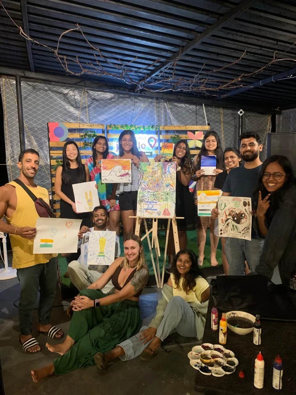 Participants holding paintings created during an art retreat