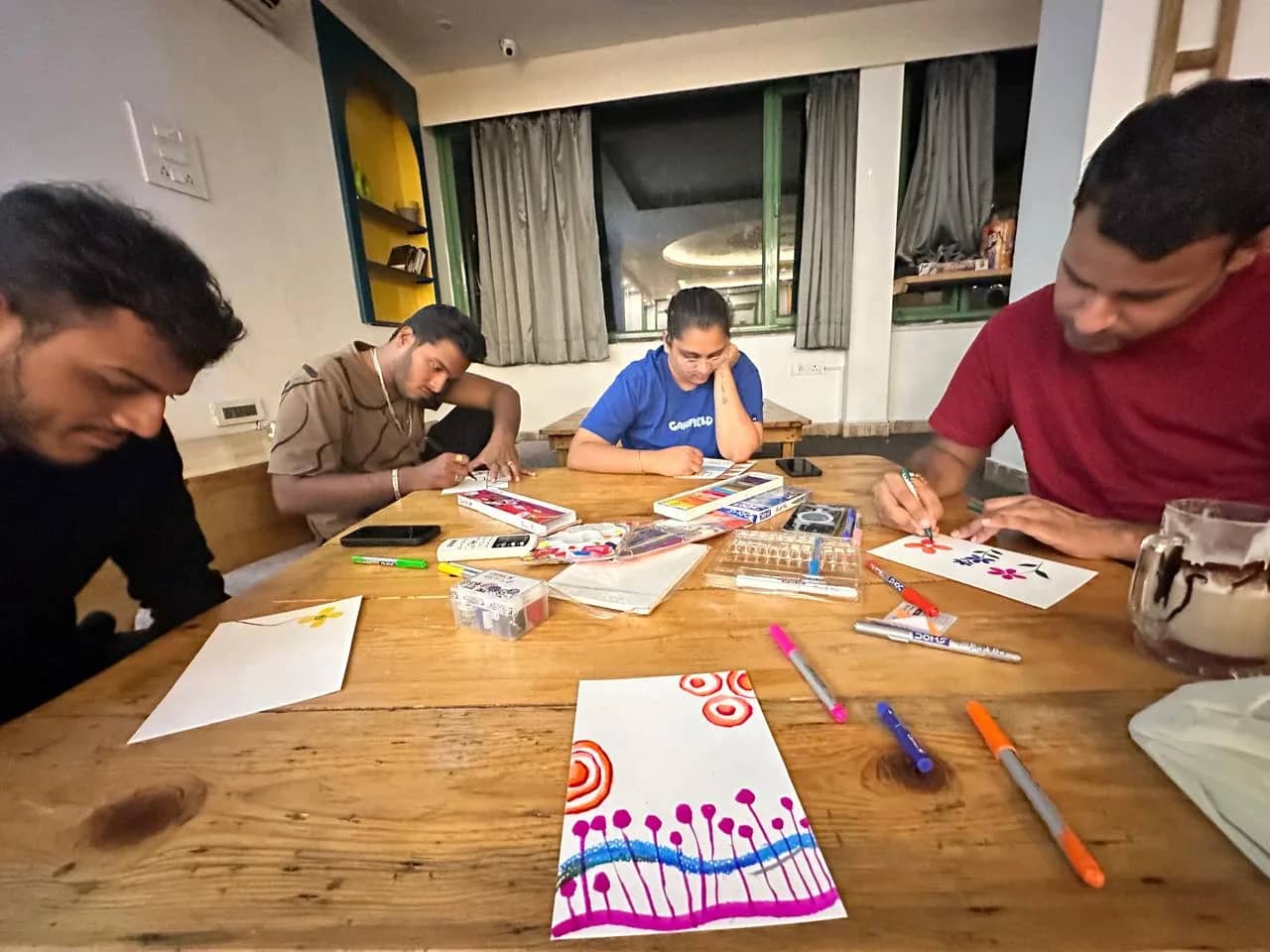Indoor expressive art workshop with painting materials during a Himalayan art retreat