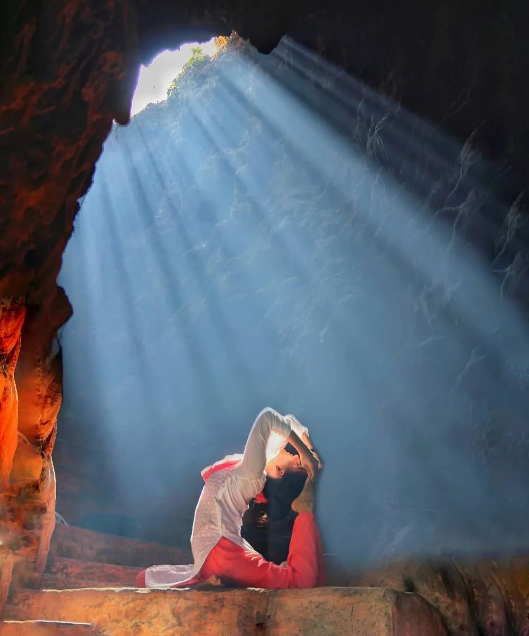 Yoga backbend pose in a natural cave during a retreat in Rishikesh
