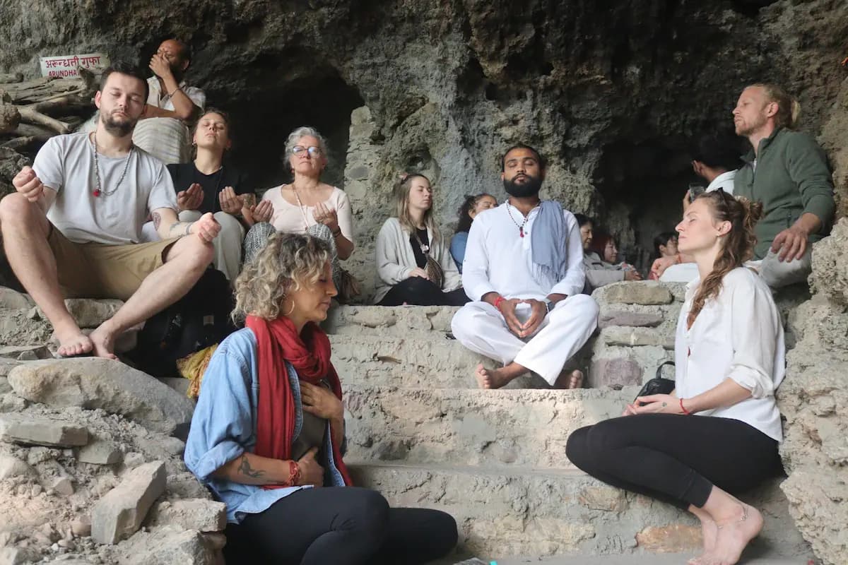 Retreat participants sitting together in meditation inside a cave