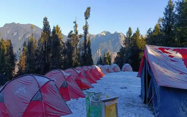 Trekkers climbing the final ridge to Kedarkantha summit in snow